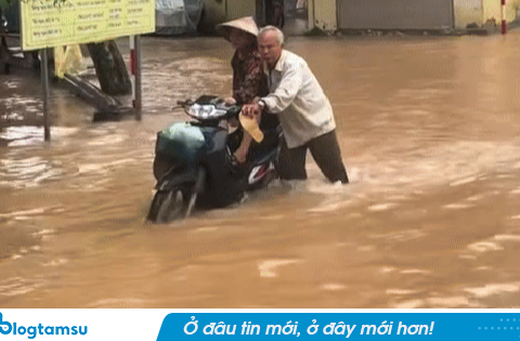 Khoảnh khắc cụ ông 70 tuổi đẩy xe chở vợ đi giữa dòng nước ngập tới gối ở Hà Nội: Hé lộ câu chuyện phía sau